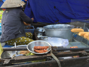 River Vendor Making a Barbecue Sandwich